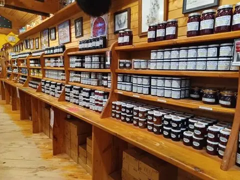 A long wall of jam jars on wooden shelves running the length of the store