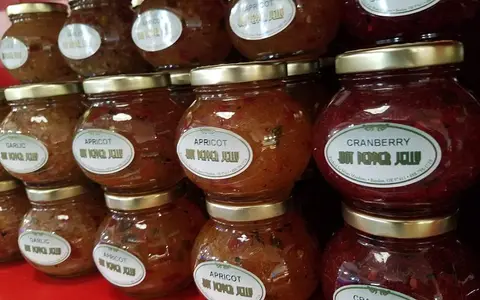 Stacked jars of garlic, apricot, and cranberry hot pepper jelly